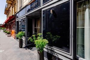 a store front with potted plants on a street at L'Adresse in Paris