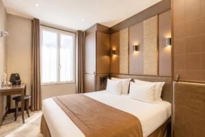 a bedroom with a bed and a desk and a window at L'Adresse in Paris