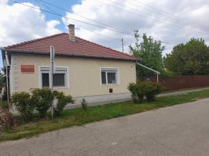 a yellow house with a red roof on a street at Ráday Apartman in Hajdúszoboszló