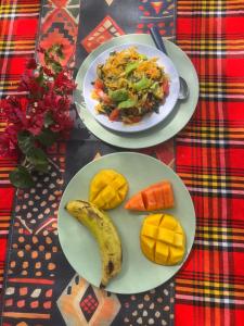 a table with two plates of food and a banana at Arbaminch eco campsite and lodge in Ārba Minchʼ