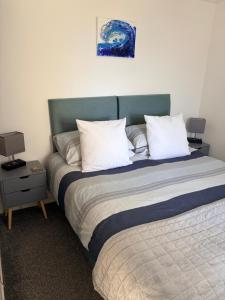 a bedroom with a large bed with white pillows at Accommodation by the sea on Sanday in Orkney