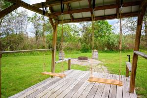 a porch with two swings on a wooden deck at Rustic Way in McArthur