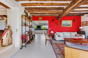 a living room with a white couch and a red wall at Maison de la Gentinière Zoo Beauval in Mareuil-sur-Cher