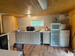 a kitchen with white cabinets and a white refrigerator at Chaty u Martiny in Nalžovice