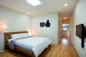 a bedroom with a bed and a flat screen tv at The BB's Jeju Resort in Seogwipo