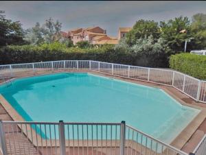 a large swimming pool with a fence around it at Maison petit havre de paix in Palavas-les-Flots