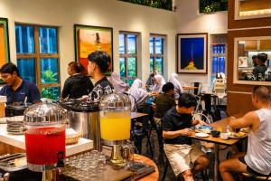 a group of people sitting at tables in a restaurant at Central City Hotel at Chinatown in Kuala Lumpur