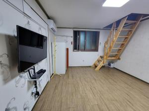 a living room with a tv and a staircase at Daecheon Sodam pension in Boryeong