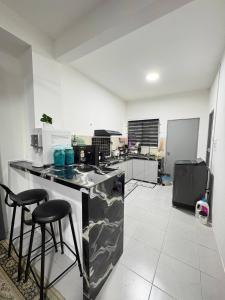 a kitchen with a counter and two bar stools at Arowana Homestay MALAY ONLY in Sungai Petani