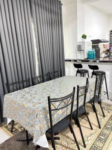 a table and chairs in a kitchen with grey curtains at Arowana Homestay MALAY ONLY in Sungai Petani +7 photos