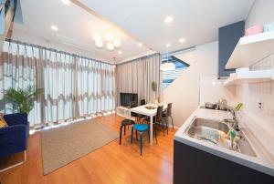 a kitchen and living room with a table and a dining room at Daecheon Boryeong the Playa Pension in Boryeong