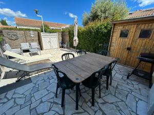 a wooden table and chairs on a patio at Maison petit havre de paix in Palavas-les-Flots