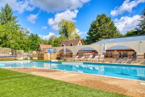 a swimming pool with chairs and a fence at Camping les Pialades - Gite in Nabirat