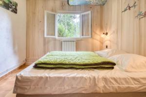 a bedroom with a bed with a green blanket on it at Camping les Pialades - Gite in Nabirat +24 photos