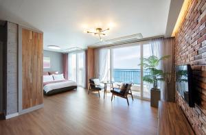 a bedroom with a bed and a balcony with the ocean at Yeongduk Brie Pension in Yŏngdŏk