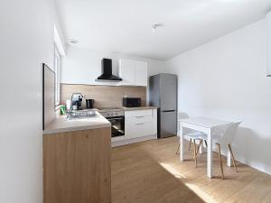 a kitchen with a table and a white table and chairs at 8C - L'Urban in Saint-Rambert-dʼAlbon