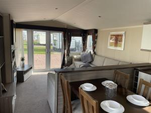a living room with a couch and a table at Linnet Moselle 5 in Peterhead
