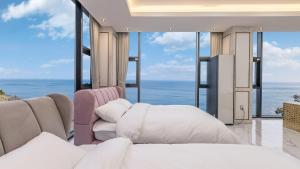 a bedroom with a bed and views of the ocean at yongdeok marryel poolvilla in Yŏngdŏk