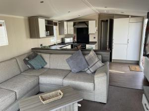 a living room with a couch and a kitchen at Linnet Moselle 5 in Peterhead