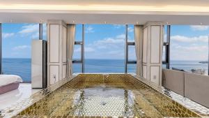 a bedroom with a tub with a view of the ocean at yongdeok marryel poolvilla in Yŏngdŏk