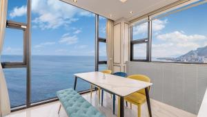 a dining room with a table and chairs and the ocean at yongdeok marryel poolvilla in Yŏngdŏk +28 photos
