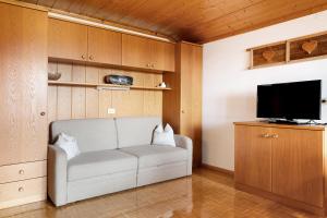 a living room with a couch and a flat screen tv at Gschtraffhof in Kastelruth