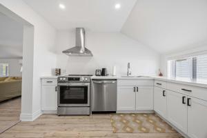 a kitchen with white cabinets and a stainless steel oven at Lake Drive apartment in Georgina +16 photos