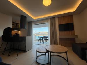 a living room with a table and a kitchen with a view at Latsis Suites in Moláoi