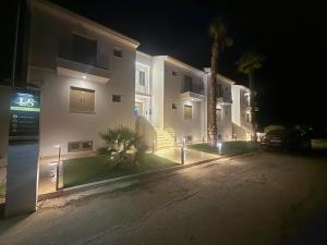 a night view of a building with a palm tree at Latsis Suites in Moláoi