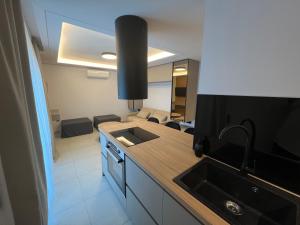 a kitchen with a sink and a living room at Latsis Suites in Moláoi