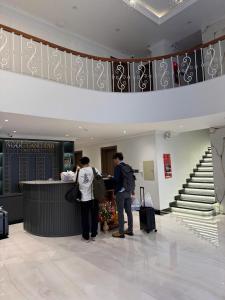 two people standing at a counter in a lobby at Ngoc Dang Anh Hotel in Nhơn Trạch