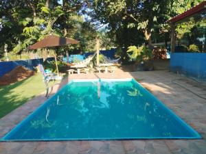 a swimming pool in a backyard with a hammock at Hostel Oasis Jaguariuna in Jaguariúna
