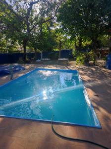 a large swimming pool with a hose in a yard at Hostel Oasis Jaguariuna in Jaguariúna +7 photos