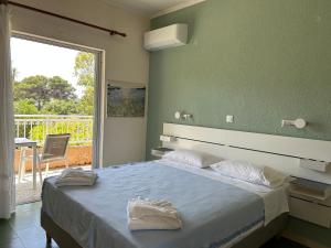 a bedroom with a large bed and a balcony at Galini Studios and Apartments in Lassi