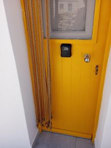 a yellow door in a room with a window at Zacharias Seaside Studio Kimolos in Kimolos