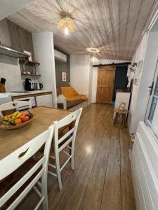 a kitchen and dining room with a table and chairs at Le Logis du Coteau in Bellefoye