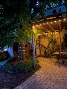 a pergola with string lights on a patio at Le Logis du Coteau in Bellefoye