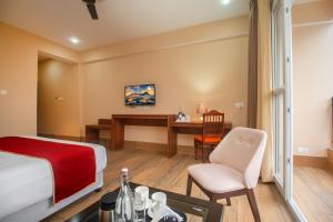 a hotel room with a bed and a desk at The Kashyap Castle in Gangtok