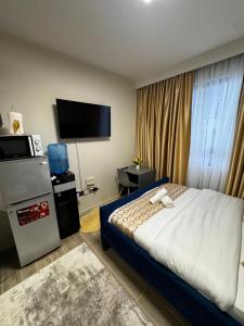 a hotel room with a bed and a flat screen tv at ZIVA HOMEs 2 in Marimbeti
