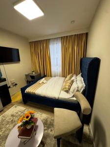 a bedroom with a bed and a chair and a table at ZIVA HOMEs 2 in Marimbeti