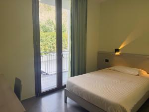 a bedroom with a bed and a large window at Hotel Piccolo Paradiso - Latronico "Terme" in Latronico
