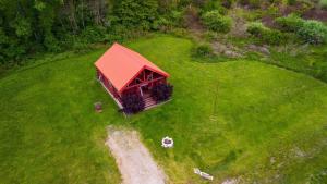 a small building with a red roof on a green field at Fisherman’s Dream in McArthur
