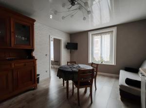 a living room with a table and a couch at Domaine Du Hêtre - Meublé T2 in Bains-les-Bains