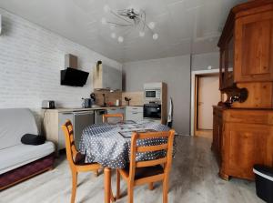 a kitchen with a table and chairs in a room at Domaine Du Hêtre - Meublé T2 in Bains-les-Bains
