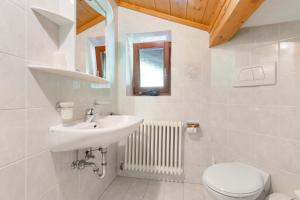 a white bathroom with a sink and a toilet at Gschtraffhof in Kastelruth +118 photos
