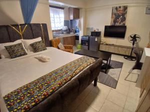 a bedroom with a large bed and a kitchen at Maridadi place in Kakamega
