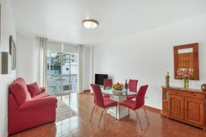 a living room with a table and red chairs at Apto Yurena 10B 2B in Los Llanos de Aridane