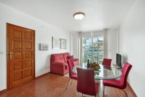 a living room with a glass table and red chairs at Apto Yurena 10B 2B in Los Llanos de Aridane