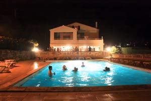 a group of people in a swimming pool at night at Le Cyprès - La Fontinelle in Bessas +9 photos
