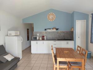 a kitchen with a wooden table and a dining room at Le Cyprès - La Fontinelle in Bessas